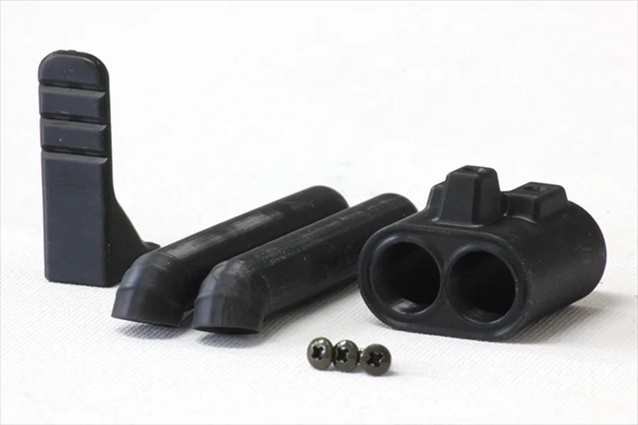 A set of unpainted black plastic RC car dual muffler parts including pipes, a mounting bracket, and small screws on a white background.