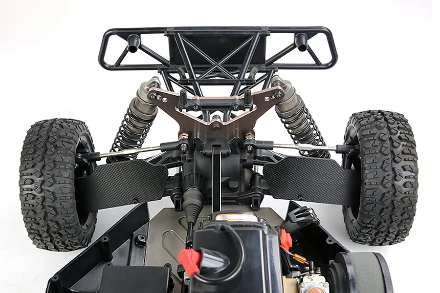 A close-up view of the rear suspension area of an RC buggy, featuring carbon fibre rear suspension arm guards installed on the lower control arms.