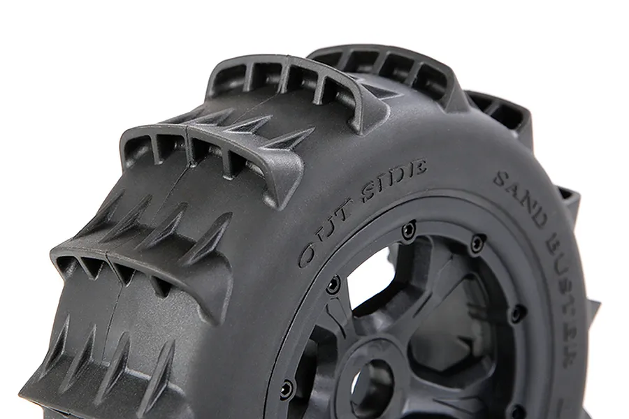 Close-up of a black Rovan 1/5 scale paddle tyre mounted on a black beadlock wheel, showing the tread pattern and sidewall markings.