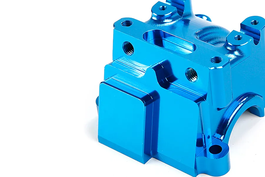 A close-up view of a bright blue anodized aluminium RC gearbox case component against a plain white background.