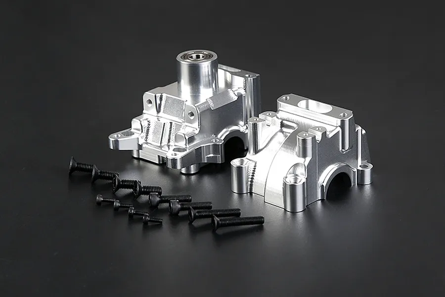 Rovan silver aluminium gearbox case set with included black mounting screws on a dark background.