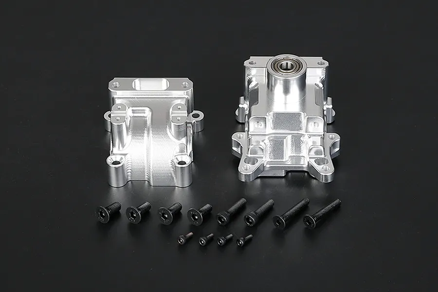 Rovan silver aluminium RC gearbox case halves with a set of black mounting screws on a dark background.