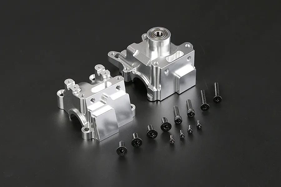 A Rovan silver aluminium gearbox case set with included black screws on a dark background.