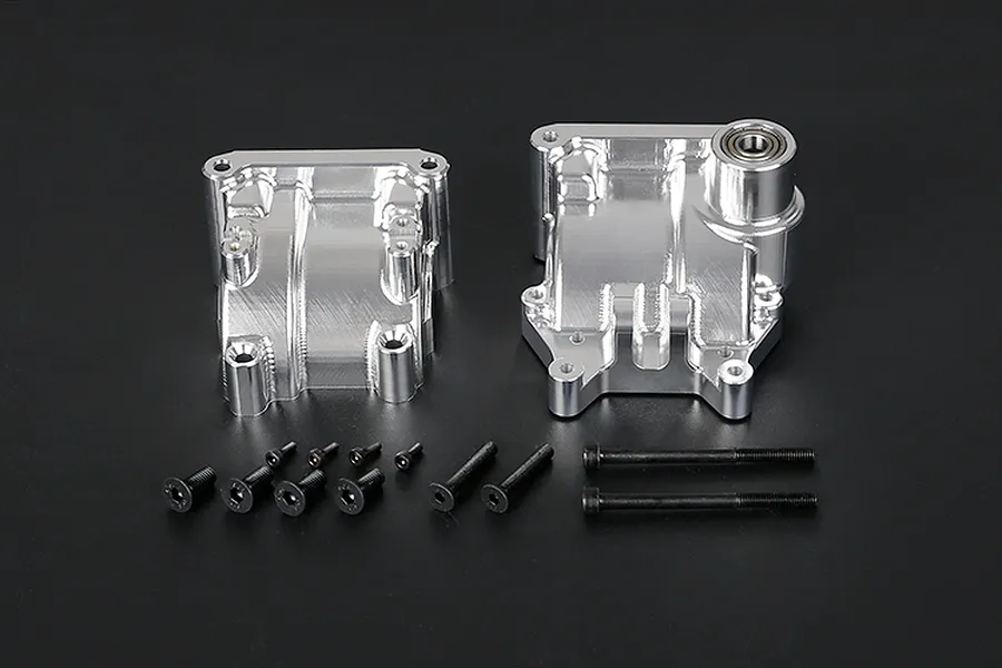 Rovan silver aluminium gearbox case set with included mounting screws and a pre-installed bearing on a black background.