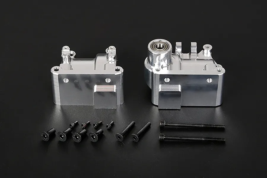 Two silver aluminium RC gearbox case halves with a set of black mounting screws on a black background.