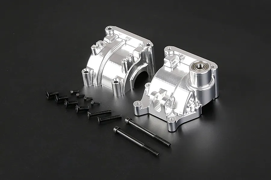 A pair of silver Rovan aluminium gearbox case halves with a set of black mounting screws on a dark background.