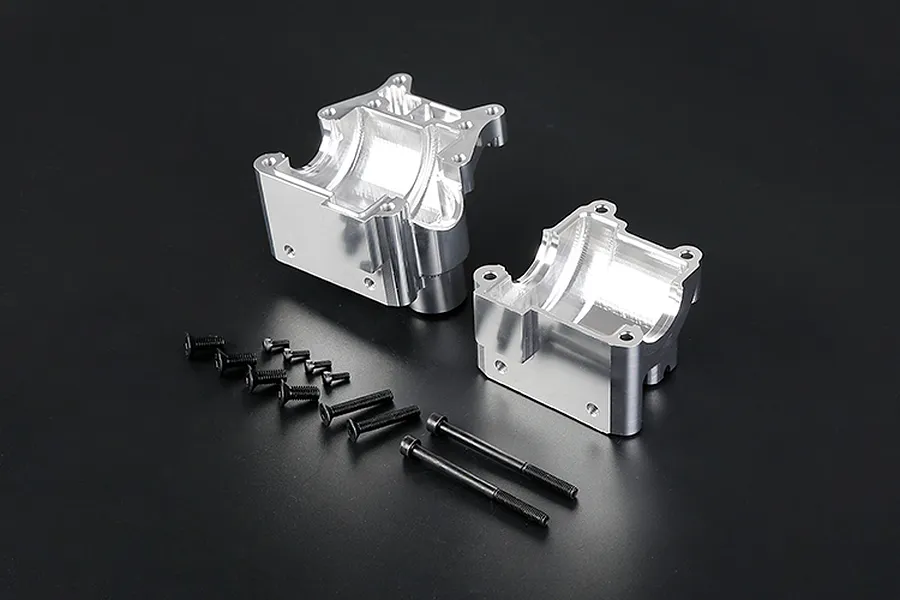 Silver Rovan aluminium gearbox case halves with a set of black mounting screws on a black background.