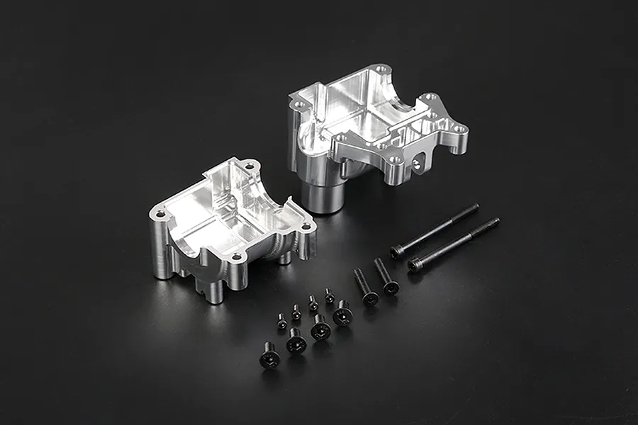 Rovan silver aluminium gearbox case halves and a set of black mounting screws on a dark background.