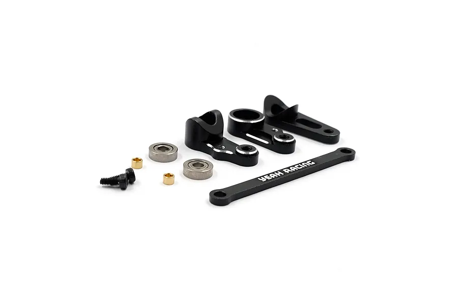 A set of black aluminium RC steering assembly parts including arms, a steering link, bearings, screws, and spacers on a white background.