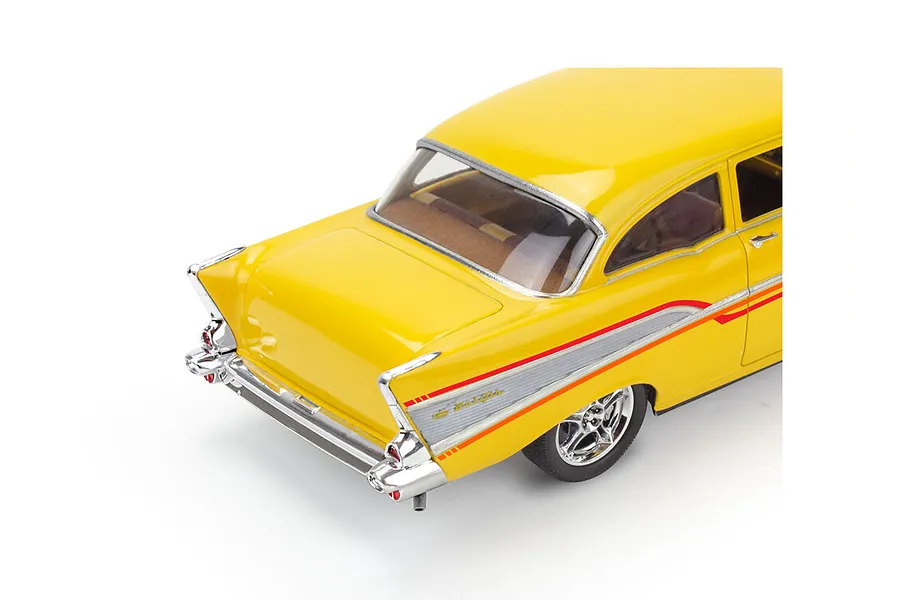 A high-angle rear view of a yellow 1957 Chevrolet Bel Air scale model car with chrome trim and red side decals on a white background.