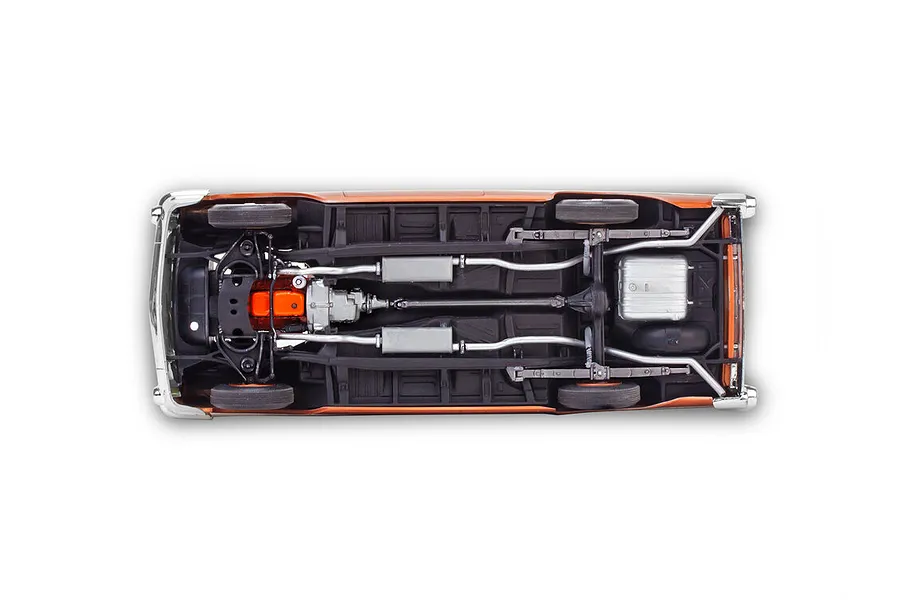 Bottom view of a 1/25 scale 1957 Chevrolet Bel Air model car showing the chassis, engine, exhaust system, and suspension details.