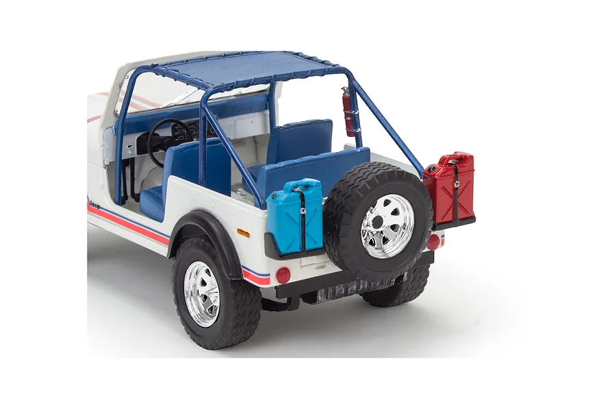 Rear three-quarter view of a white Revell 1/24 scale 1977 Jeep CJ-7 plastic model kit with blue interior, roll cage, spare tire, and fuel cans.