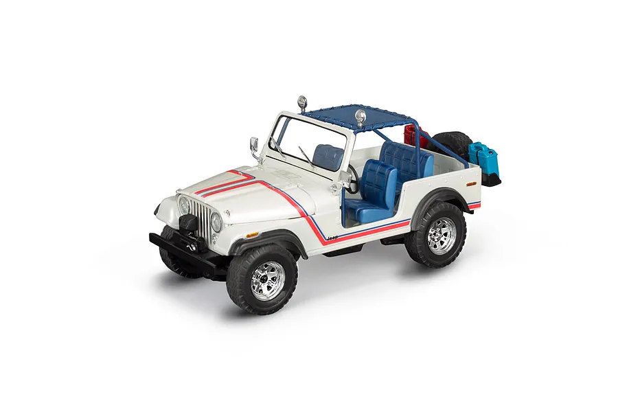 A 1/24 scale model of a white 1977 Jeep CJ-7 with blue interior, red and blue racing stripes, and off-road accessories on a white background.