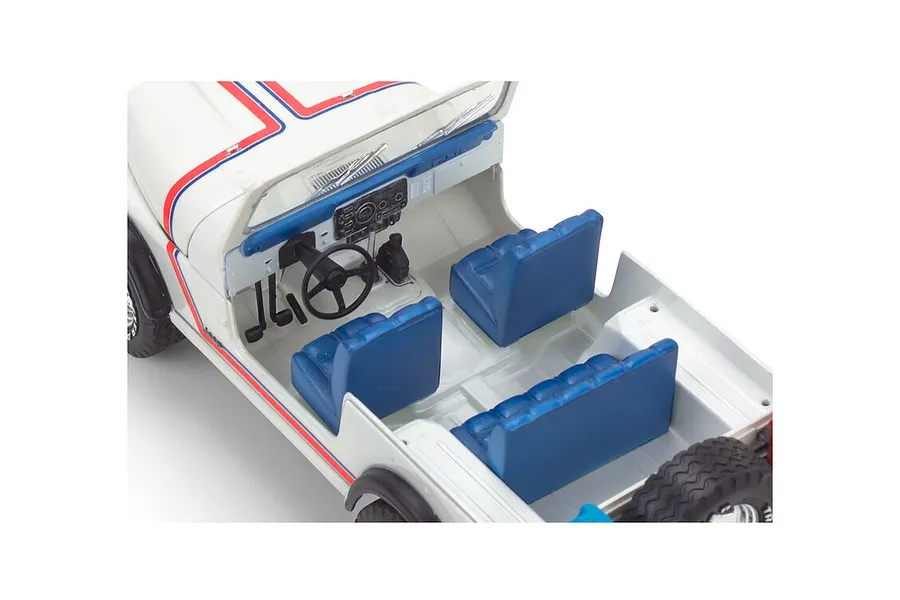 High-angle interior view of a 1/24 scale Revell 1977 Jeep CJ-7 plastic model kit showing blue seats, dashboard, and steering wheel.