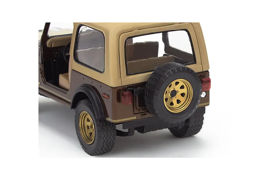 Rear three-quarter view of a 1/24 scale model of a 1977 Jeep CJ-7, featuring a brown body, tan soft top, and gold wheels.