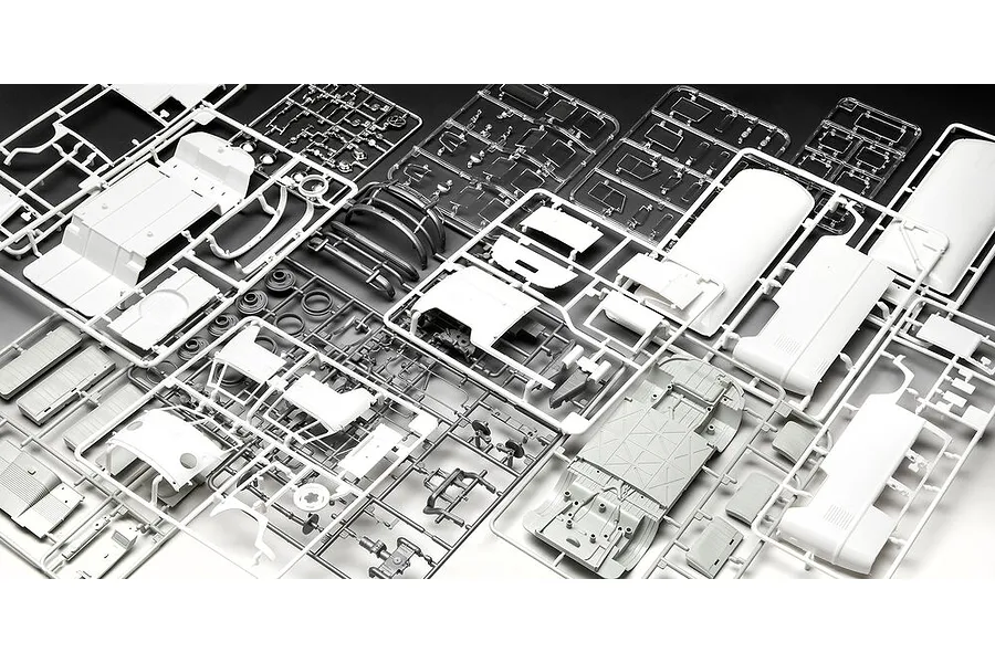 Multiple plastic model kit sprues for a Revell VW T1 Bus model, showing various white and clear plastic parts on a dark background.