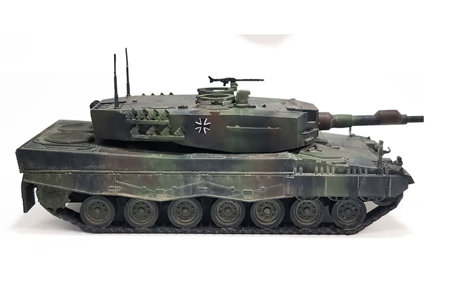 A side view of a camouflaged Leopard 2A4 tank model kit on a white background.