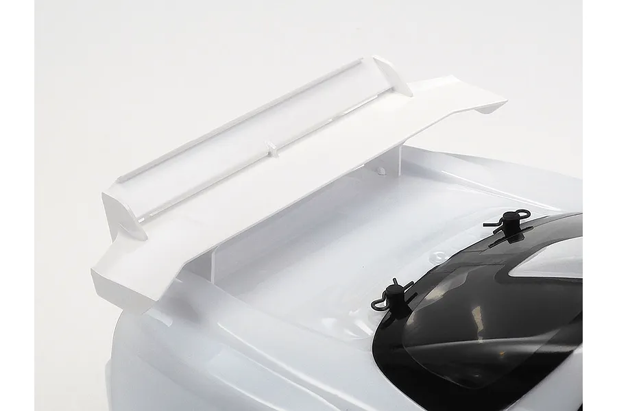 Close-up of the rear spoiler and roof section of a white Tamiya 1998 Honda NSX RC car body shell against a white background.
