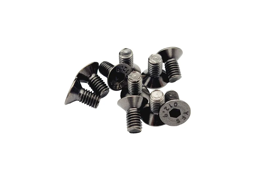 A small pile of dark grey metal countersunk hex head screws with visible 12.9 grade markings on the heads.