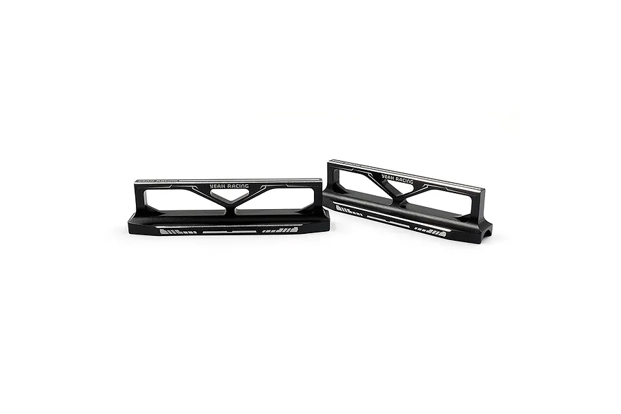 Two black anodized aluminum Yeah Racing droop blocks for RC cars, featuring laser-etched branding and markings on a white background.