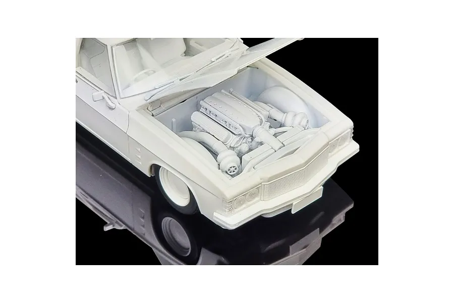 A high-angle view of an unpainted white plastic model car kit of a 1975 Holden HJ Panelvan, showing the engine bay with the hood open.