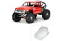 A composite image showing a fully assembled red 1985 Toyota Hilux RC crawler and an inset of the clear, unpainted polycarbonate body shell.