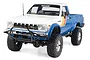RC4WD Trail Finder 2 1982 Toyota Pickup RC rock crawler in blue and white with retro decals, shown from a front three-quarter angle on a white background.