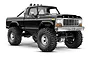 A black Traxxas TRX-4M Ford F-150 High Trail RC rock crawler truck shown from a front three-quarter angle on a white background.