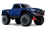 A blue Traxxas TRX-4 Sport RC rock crawler truck with large black off-road tires and a black front bumper, shown against a white background.