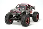 Tamiya CR-01 Rock Socker RC rock crawler, a 1/10 scale electric 4WD truck with a grey digital camo body, red accents, and large off-road tires.