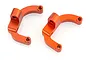 Two orange anodized aluminium C-shaped RC car suspension or steering mounts on a white background.
