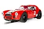 A red Scalextric 1/32 scale Shelby Cobra 289 slot car with white racing stripes and the number 32 on the hood and doors, positioned on a track.