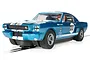 A blue Scalextric 1/32 scale Shelby Mustang GT350 slot car with white racing stripes and the number 133 on the side, positioned on a slot car track.