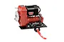 RC4WD 1/10 scale Warn 8274 winch with red housing, black motor, and red winch line on a black mounting plate.
