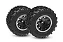 Two Traxxas Sledgehammer RC monster truck tires mounted on black and satin wheels, shown from a front-quarter angle against a white background.