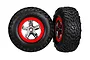 Two Traxxas 2.2/3.0 inch off-road RC tires mounted on red and chrome five-spoke wheels against a white background.