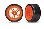 Two RC car wheels with bright orange split-spoke rims and smooth black hard plastic drift tyres, shown from front and side angles.