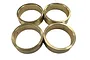 Four circular brass wheel weights for RC vehicles arranged in a two-by-two grid on a white background.