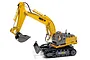 Huina 1531 RC excavator toy in yellow and grey with a front blade, tracked base, and operator figure inside the cab.