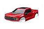 A red Traxxas Ford Raptor R RC truck body shell viewed from a high angle against a white background.