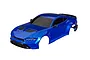 A blue painted RC car body shell for a 1/10 scale Ford Mustang, featuring black trim, grille, and spoiler against a white background.