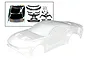 A clear, unpainted Traxxas 1/10 Ford Mustang RC body shell shown with included black plastic accessories and decal sheet.