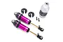 Two pink Traxxas GTR aluminium shock absorbers with gold shafts, two black plastic spring retainers, two small screws, and a bottle of Traxxas shock oil.