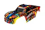 Traxxas 1/10 scale Hoss VXL truck body shell in Solar Flare paint scheme with red, yellow, and blue abstract graphics.