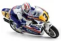 Kyosho 1/8 scale Honda NSR500 1991 RC motorcycle model with rider figure leaning into a turn, featuring white, blue, and yellow racing livery.