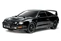 A studio shot of a black Tamiya Toyota Celica GT-Four RC car on a white background, showing the detailed body, wheels, and rear spoiler.