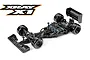 A high-angle studio shot of an XRAY X1 1/10 scale RC Formula One car chassis, featuring carbon fiber components, black wheels, and electronic components installed.