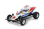 Tamiya Super Storm Dragon 1/10 scale 2WD RC buggy kit, featuring a white body with blue and red flame decals, number 18, and off-road tires.