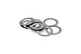 A small pile of thin, circular stainless steel rocker shims used for RC car maintenance.