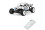 A fully assembled RC buggy with a silver VW Baja Bug body shell, alongside an inset image of the unpainted clear body shell in its packaging.